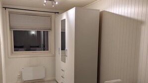 A bedroom with two beds, a wardrobe, a radiator, and a window with blinds. - Modern apartment near train station (H77A) (Narvik)