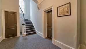 A hallway with a carpeted floor, a staircase, and two doors labeled 2 and 3.