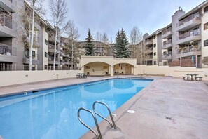 A swimming pool with a clear blue water, surrounded by apartment buildings with balconies and outdoor seating areas. - Sauna & Ski Shuttle Access: Mtn-view Condo in Avon (Avon)