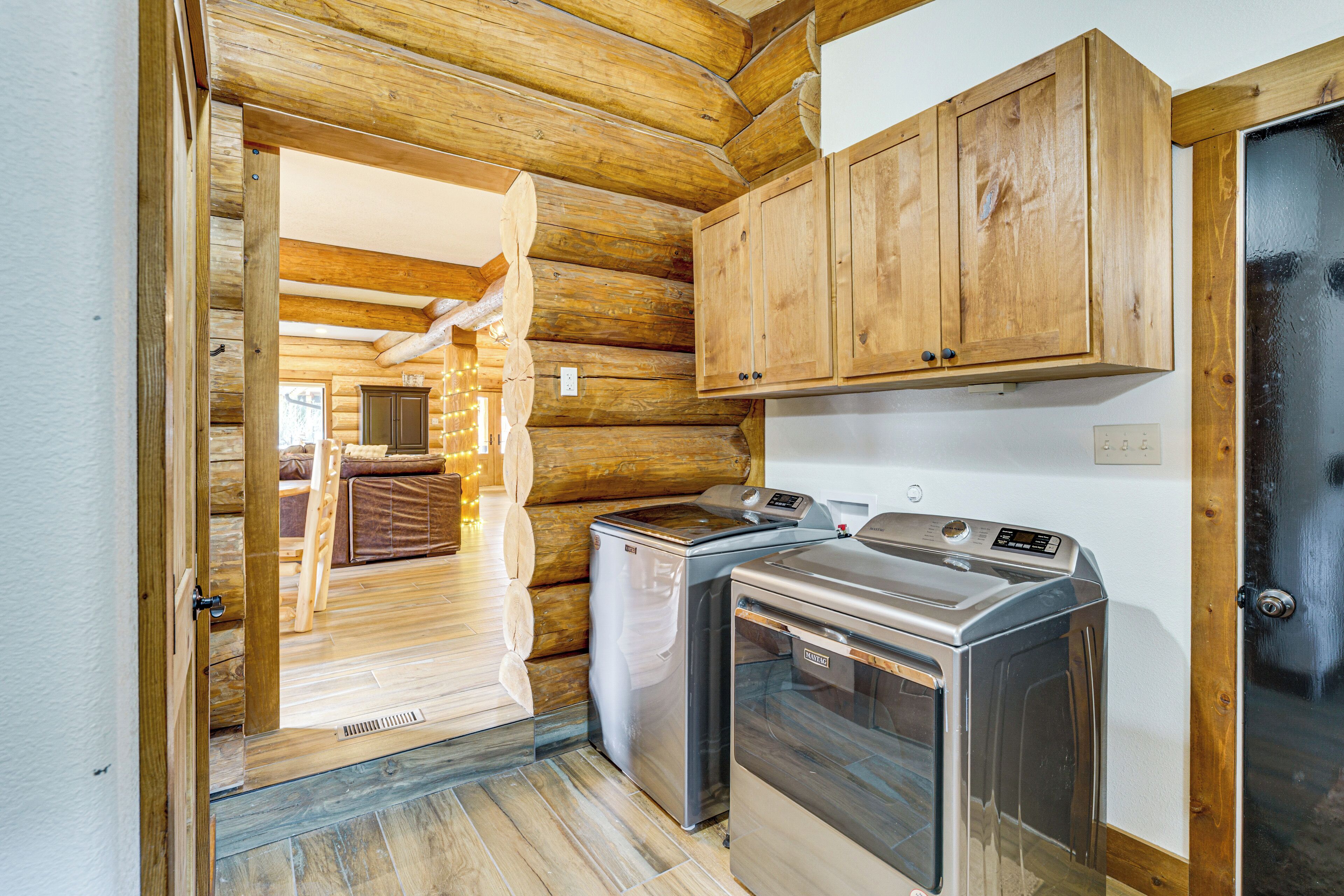 A compact kitchen with wooden cabinets, a washing machine, and a dryer.