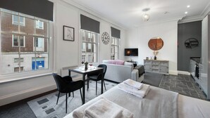 Een moderne hotelkamer met een bed, een bureau, een stoel, een televisie en uitzicht.
