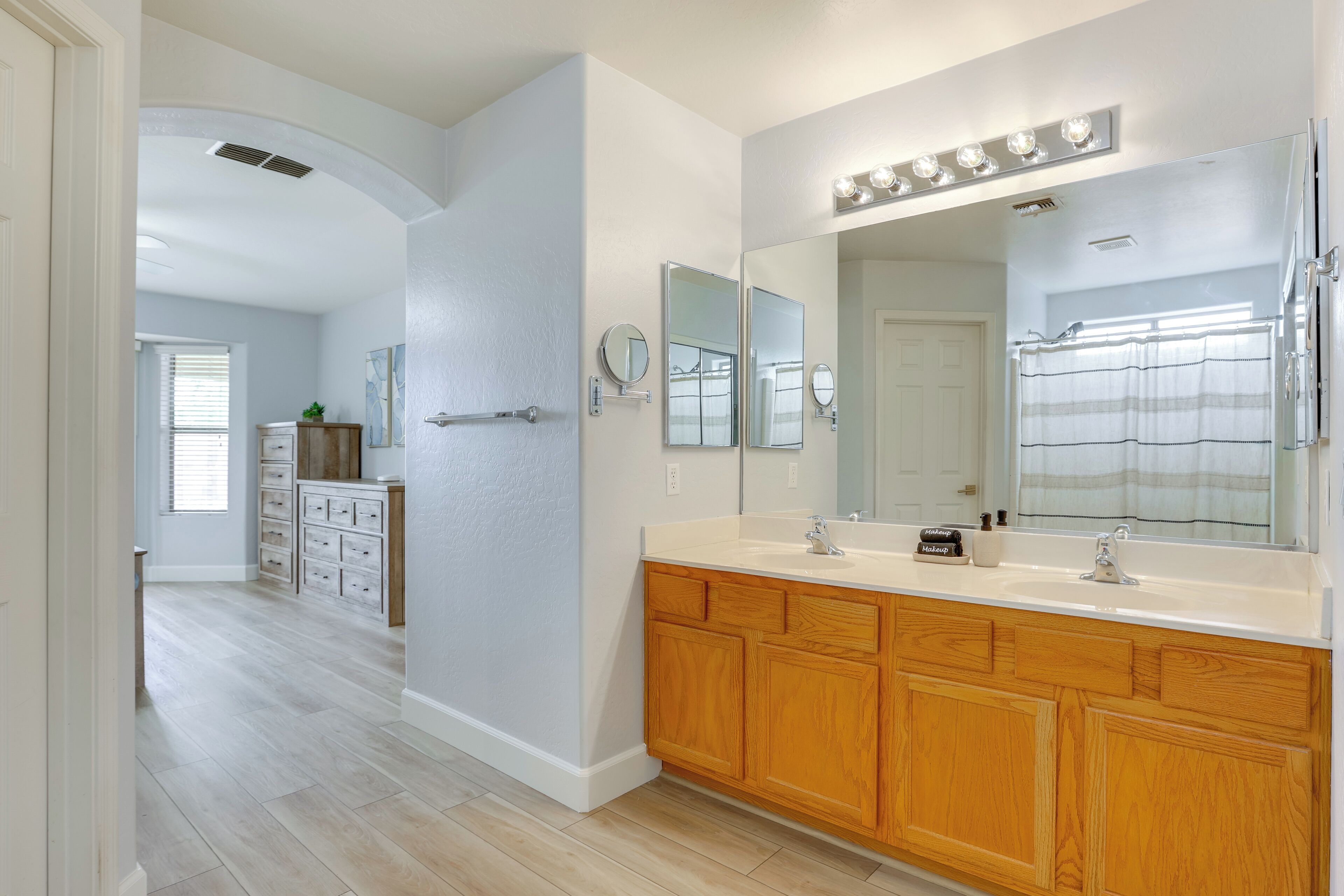 A modern bathroom with a large vanity, double sinks, and a walk-in shower.