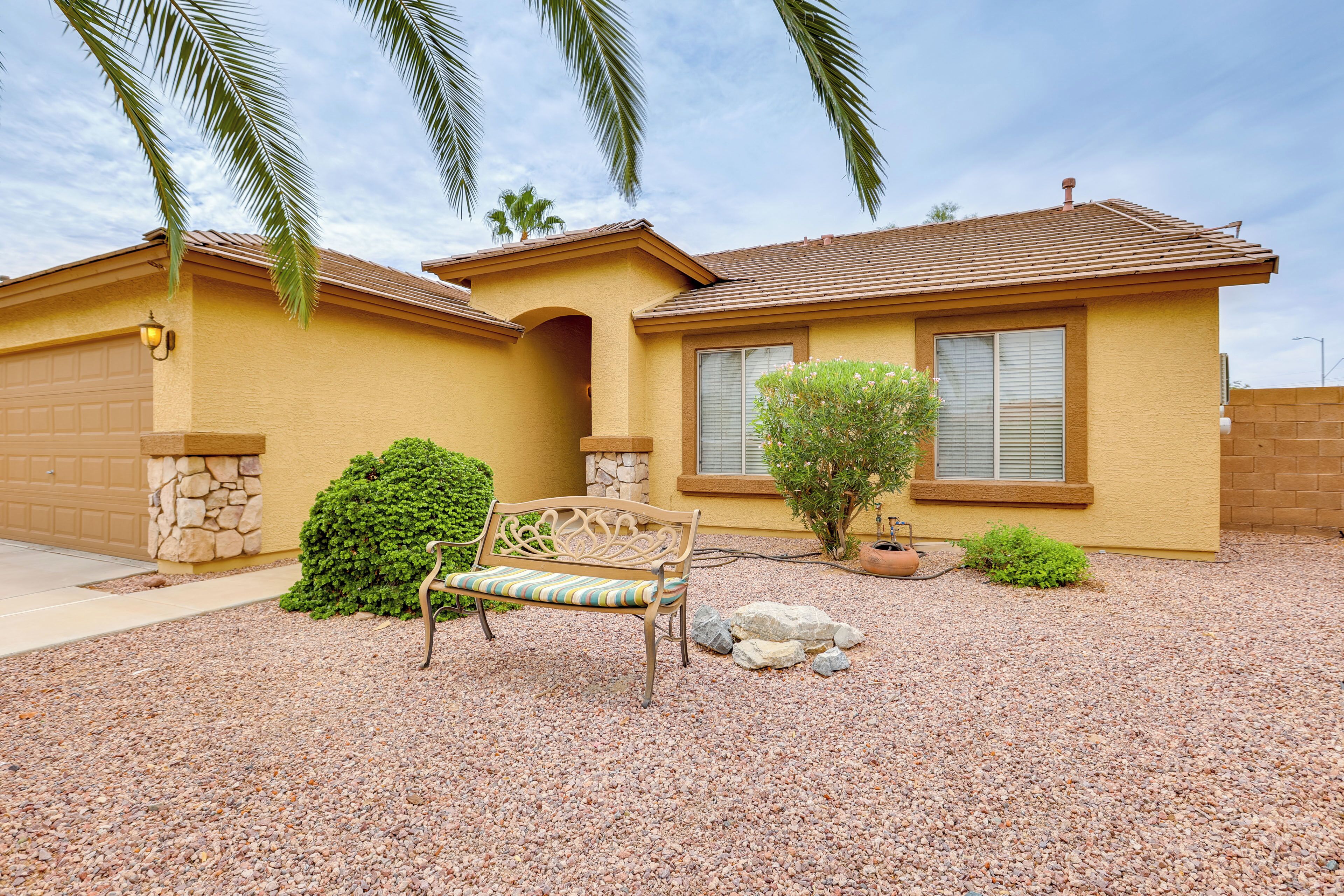 A residential house with a patio, a bench, and a small garden.