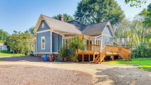 A two-story house with a porch and a wooden staircase leading to a deck. - Walk to Mcdonough Square: Historic Home w/ Yard! (McDonough)