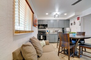 A compact kitchen with grey cabinets, a dining table with chairs, and a sofa with cushions. - Pet-friendly El Paso Apt by Hospital & Zoo (El Paso)