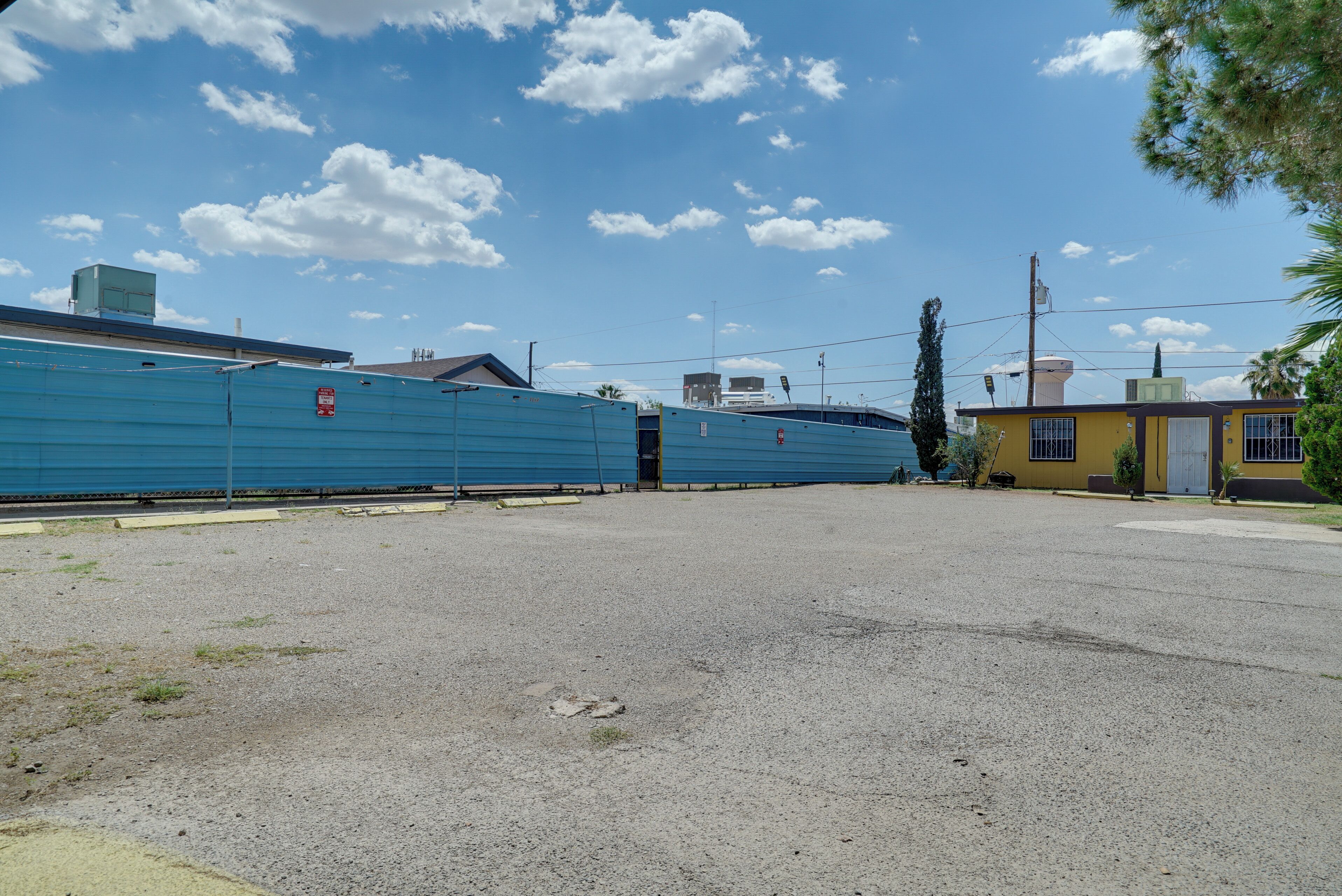 A large, open parking lot with a blue building in the background.
