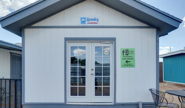 A small building with a sign for a 24-hour laundry service and vending machines. - Gated El Paso Apt Near UMC & Texas Tech (El Paso)