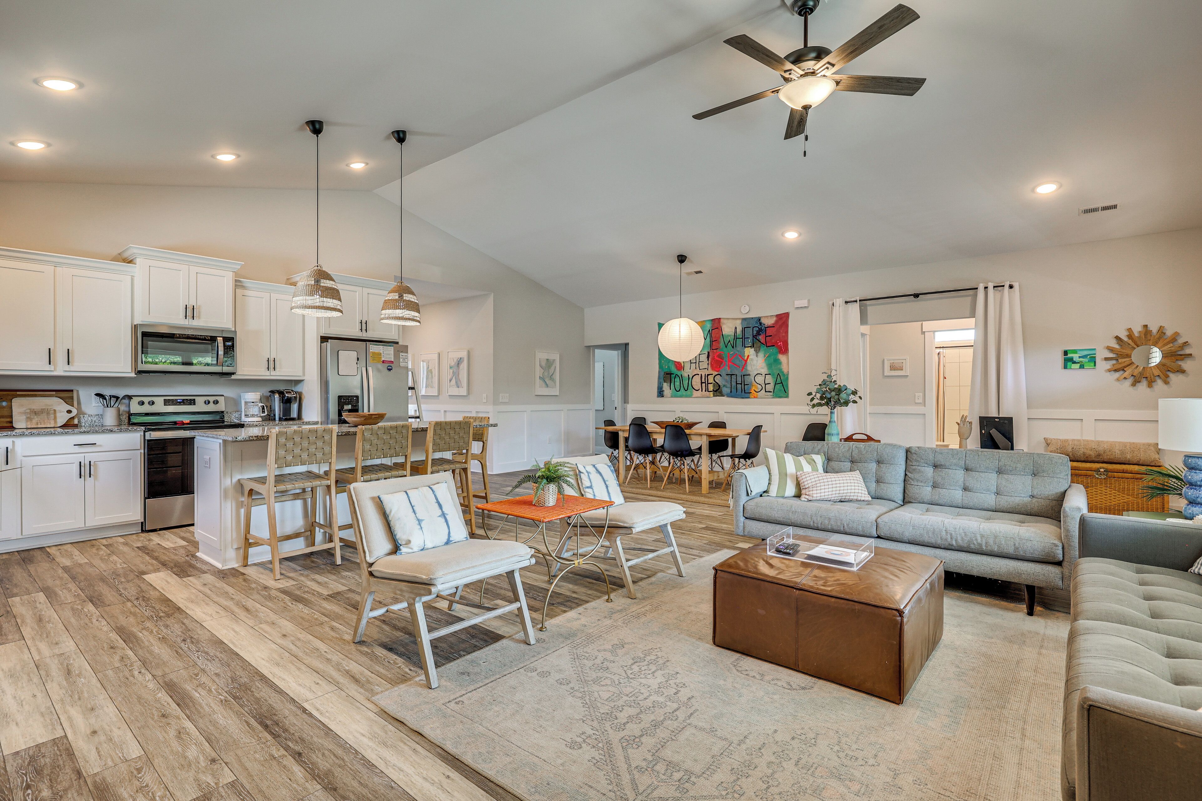 A spacious living area with a dining set, sofas, and a coffee table.