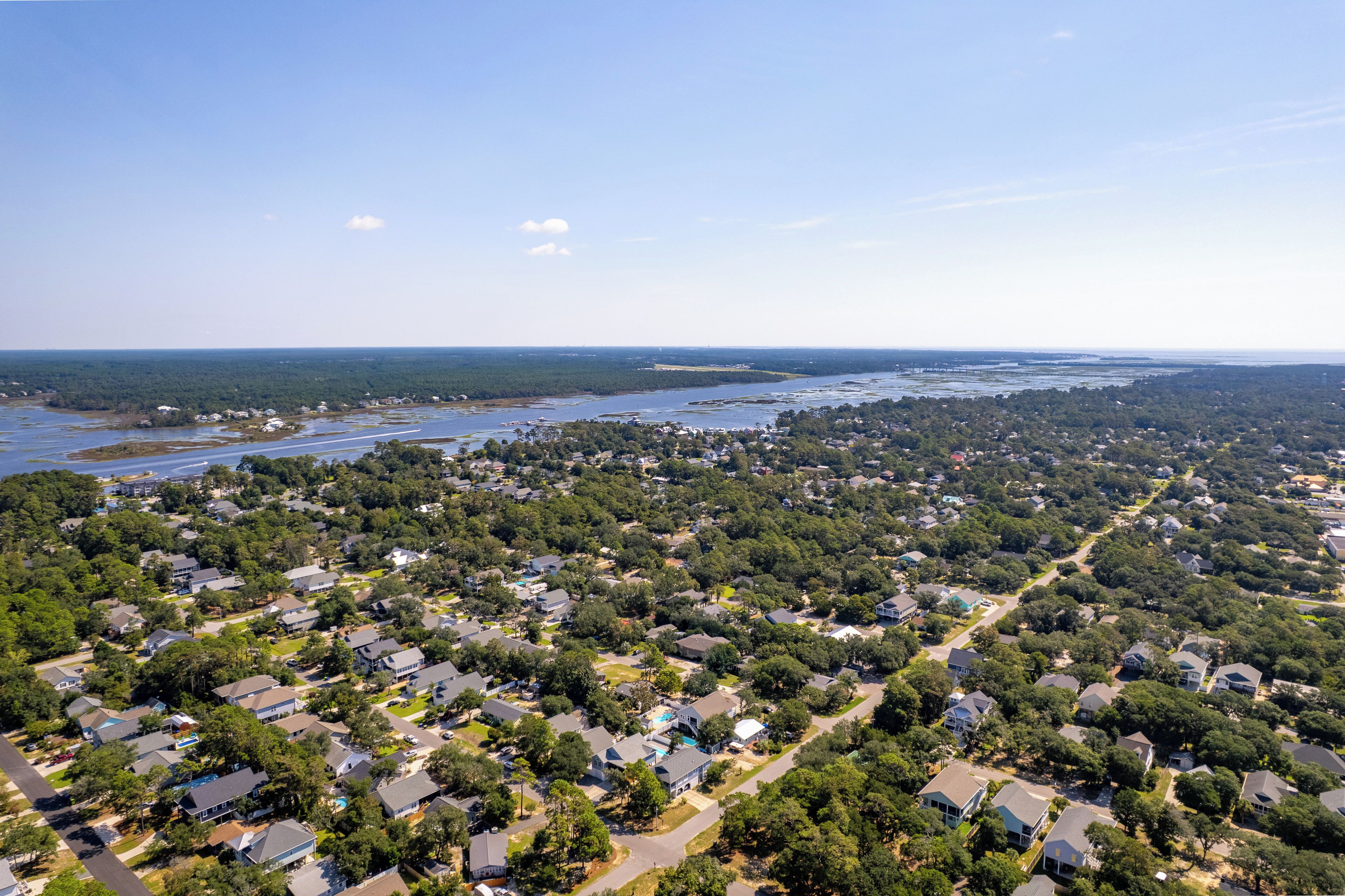 An aerial view of a residential area with houses, roads, and a body of water.
