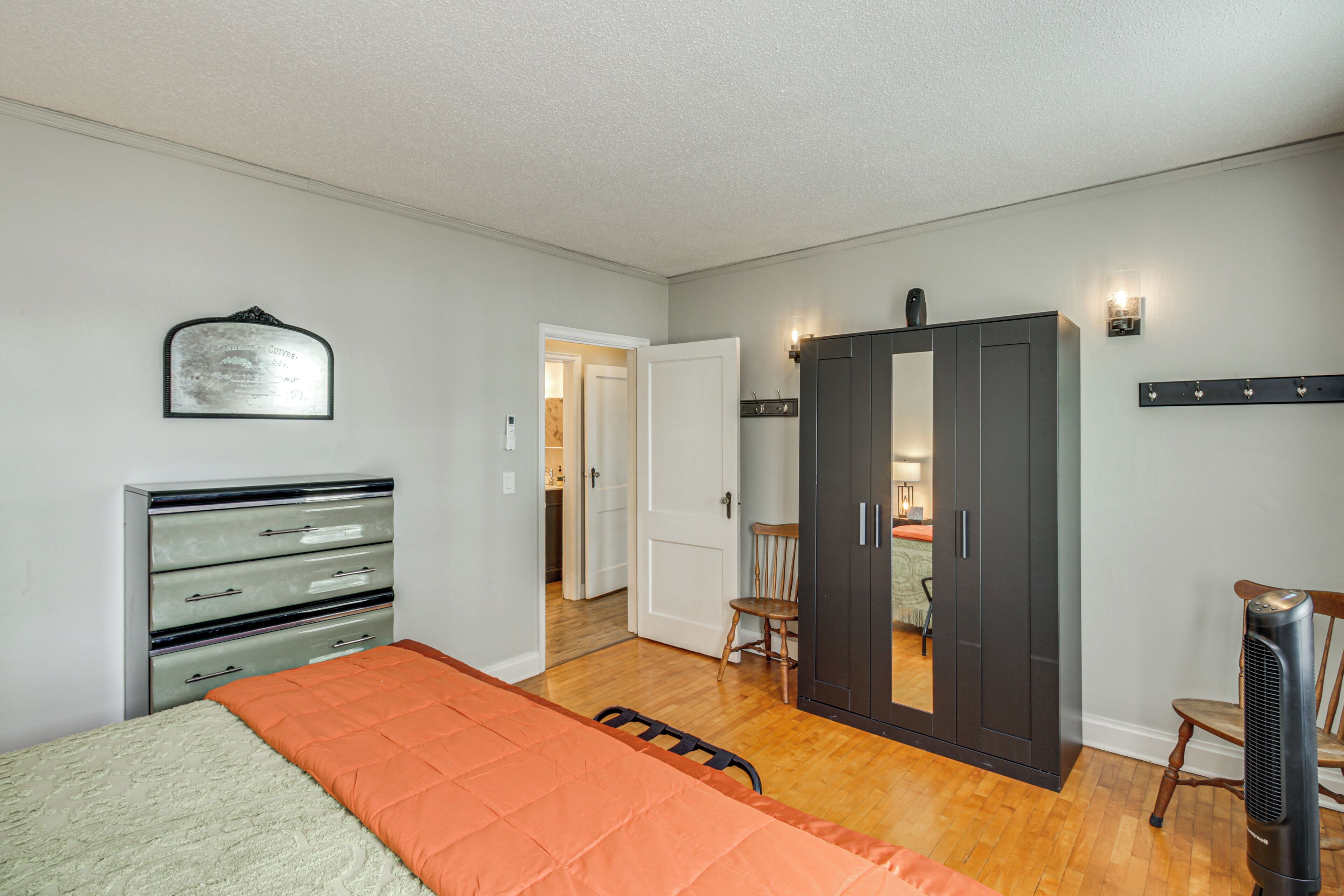 Une chambre à coucher comprenant un lit, une commode, une armoire et une chaise.