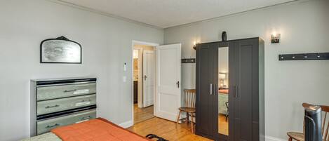 Une chambre à coucher comprenant un lit, une commode, une armoire et une chaise.