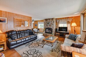 A cozy living room with a fireplace, leather sofa, and a television.