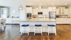 A spacious kitchen with white cabinets, a large island with bar stools, and modern appliances. - Spacious Townhome 2 Mi to Bethany Beach Boardwalk (Frankford)