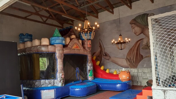 A play area with a trampoline, inflatable castle, and a mural. - Apartment 'Child-Friendly at the Village Shop' with Private Terrace and Wi-Fi (Blankenheim)