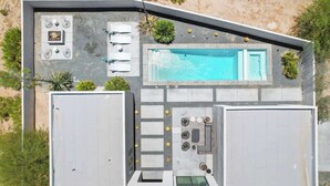 A modern house with a swimming pool, outdoor seating, and a patio area. - Aria • Fully-Fenced Pool & Hot Tub, Luxury Design (Yucca Valley)