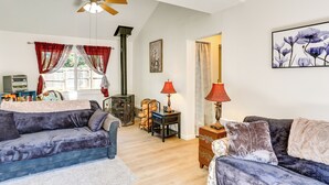 A cozy living room with a blue sofa, a wooden coffee table, and a red lamp. - Private Horse Stall: Unplug at Shingletown Home! (Shingletown)