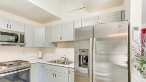 A modern kitchen with stainless steel appliances, white cabinetry, and a built-in water dispenser. - Private Horse Stall: Unplug at Shingletown Home! (Shingletown)