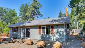 A small, single-story building with a sloped roof, large windows, and a gravel driveway. - Private Horse Stall: Unplug at Shingletown Home! (Shingletown)