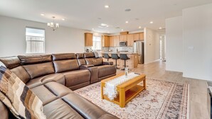 A modern living room with a leather sectional sofa, a wooden coffee table, and a patterned rug.