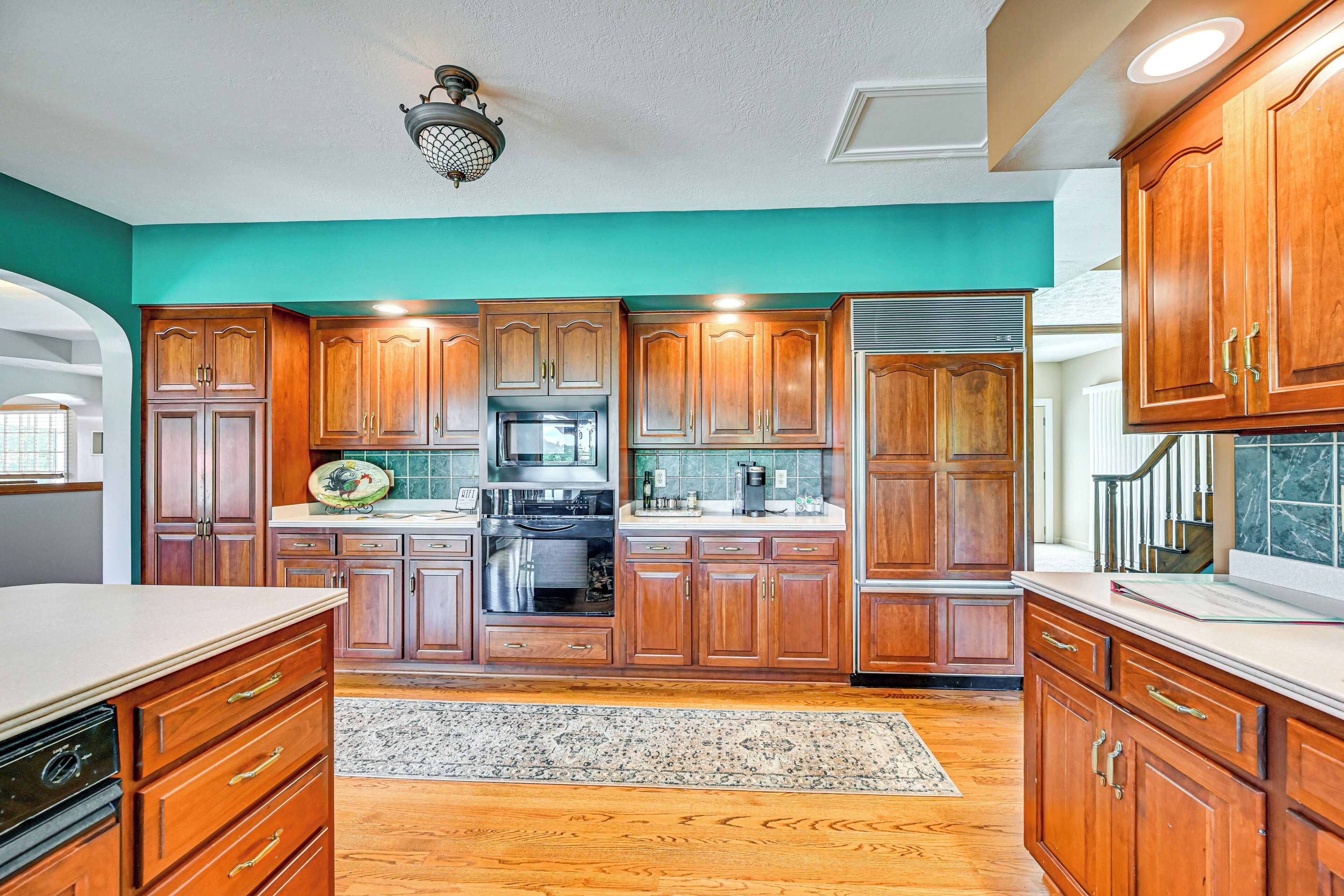 A kitchen with wooden cabinets, a stainless steel refrigerator, and a microwave.