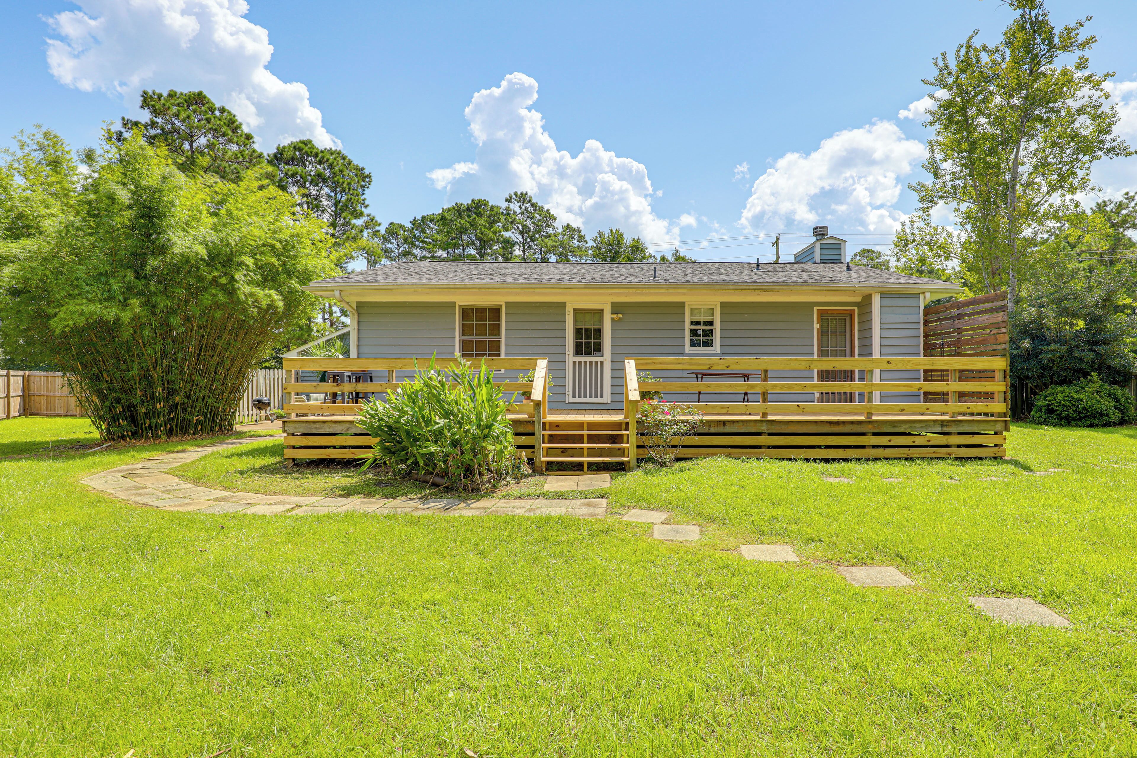 A single-story house with a front porch, a small deck, and a fenced yard.