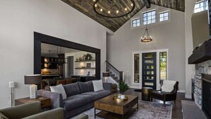 A spacious living room with a high ceiling, a fireplace, and a large mirror. - FairwayView, HotTub, Firepit, Chef Kit, GameRm, EV (Cle Elum)
