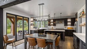 A modern kitchen with a central island, pendant lighting, and a view of the outdoors. - FairwayView, HotTub, Firepit, Chef Kit, GameRm, EV (Cle Elum)