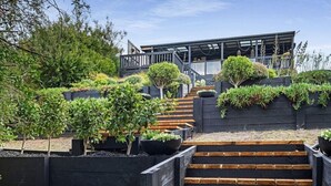 A modern house with a wooden staircase leading to a deck. - Rye Coastal Haven : 3  BR, 2  BA House in Rye, Sleeps 6 (Rye)