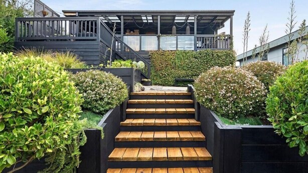A modern building with a wooden staircase leading to a covered outdoor area. - Rye Coastal Haven : 3  BR, 2  BA House in Rye, Sleeps 6 (Rye)