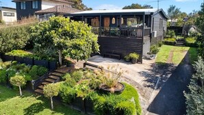 A modern house with a covered porch, a well-maintained garden, and a basketball court. - Rye Coastal Haven : 3  BR, 2  BA House in Rye, Sleeps 6 (Rye)