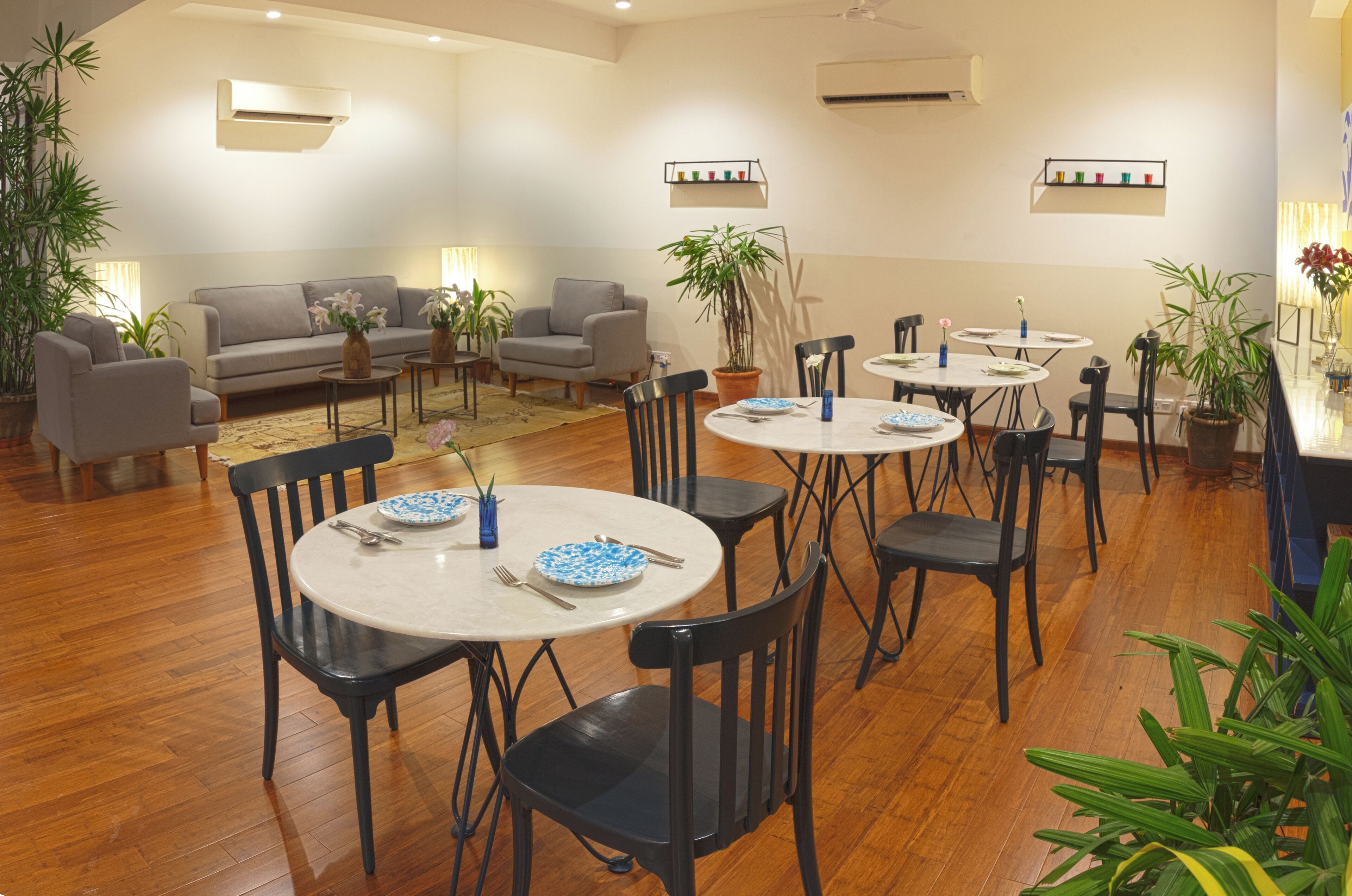 Amplia sala de estar con sofá, sillones y mesa de comedor con platos y cubiertos.