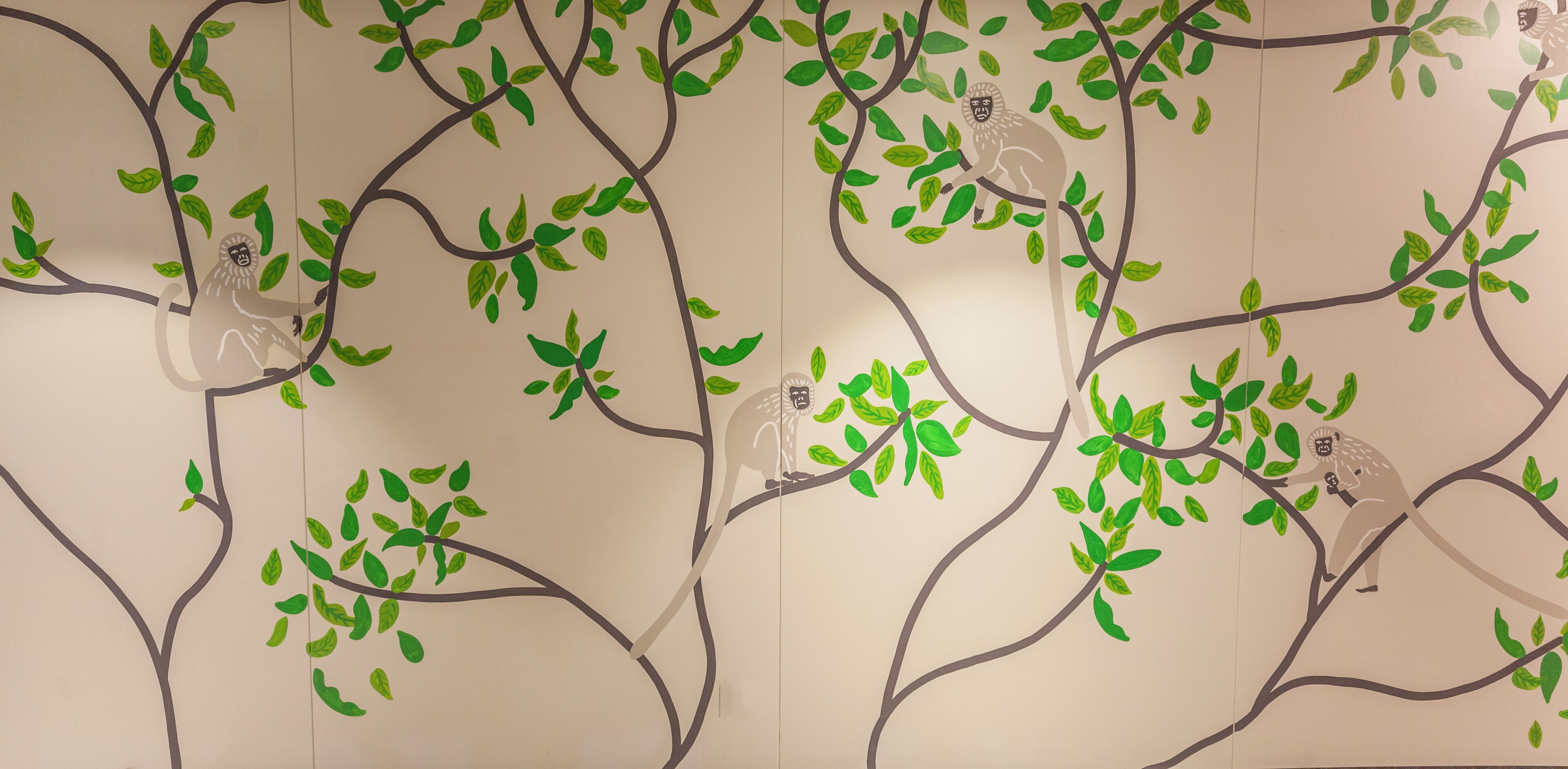 A wall with a tree branch pattern and a monkey figure.
