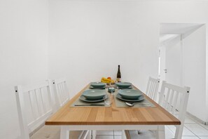 A dining table set with green plates, a wine bottle, and fruit. - Haven of peace for people & dogs with terrace (Andernach)