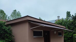 En liten, envåningsbyggnad med ett platt tak och en överbyggd entré.