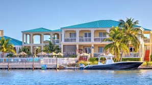Une propriété située au bord de l’eau, avec un grand bâtiment doté de balcons, d’un quai et d’un bateau.