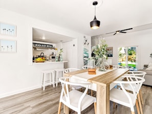 Eine moderne Küche mit weißen Schränken, einem Holzespeisetisch und einem Deckenventilator.