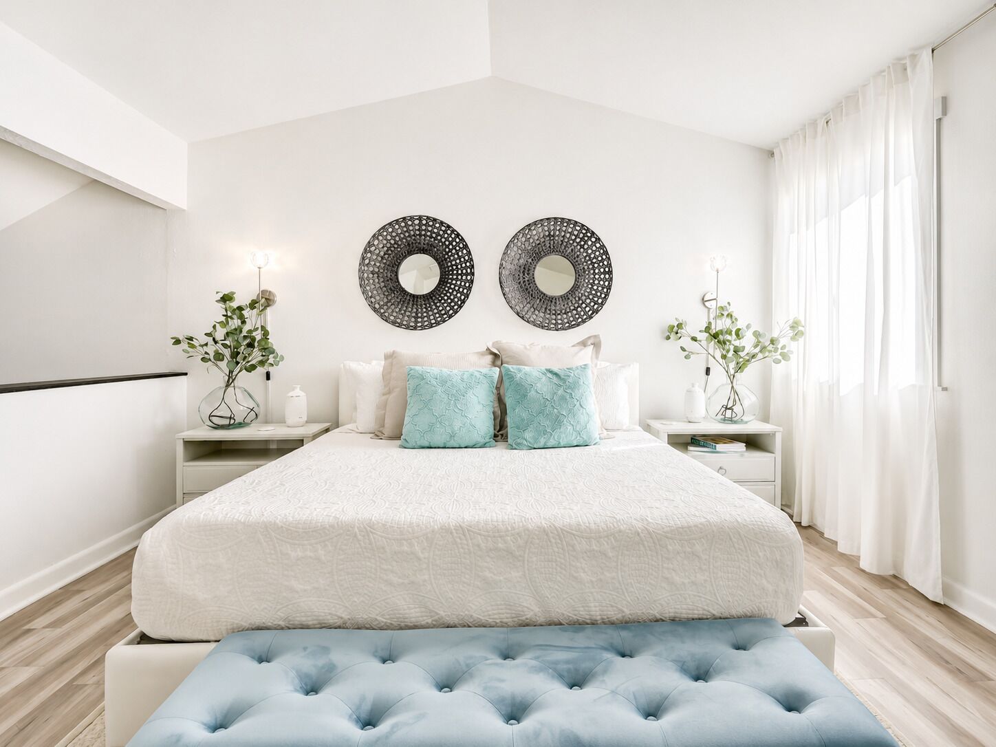 Une chambre à coucher moderne avec un grand lit, deux tables de chevet et un banc.