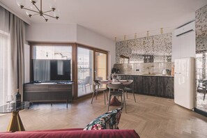A modern living room with a TV, dining area, and kitchen. - Rojo Wine Design Studio Centrum (Bydgoszcz)