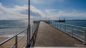 Un muelle que se adentra en aguas tranquilas bajo un cielo despejado.