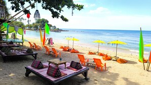 A beachside restaurant with outdoor seating, including lounge chairs and tables, and umbrellas providing shade. - Le Panpurie Koh Lanta Resort (Ko Lanta)