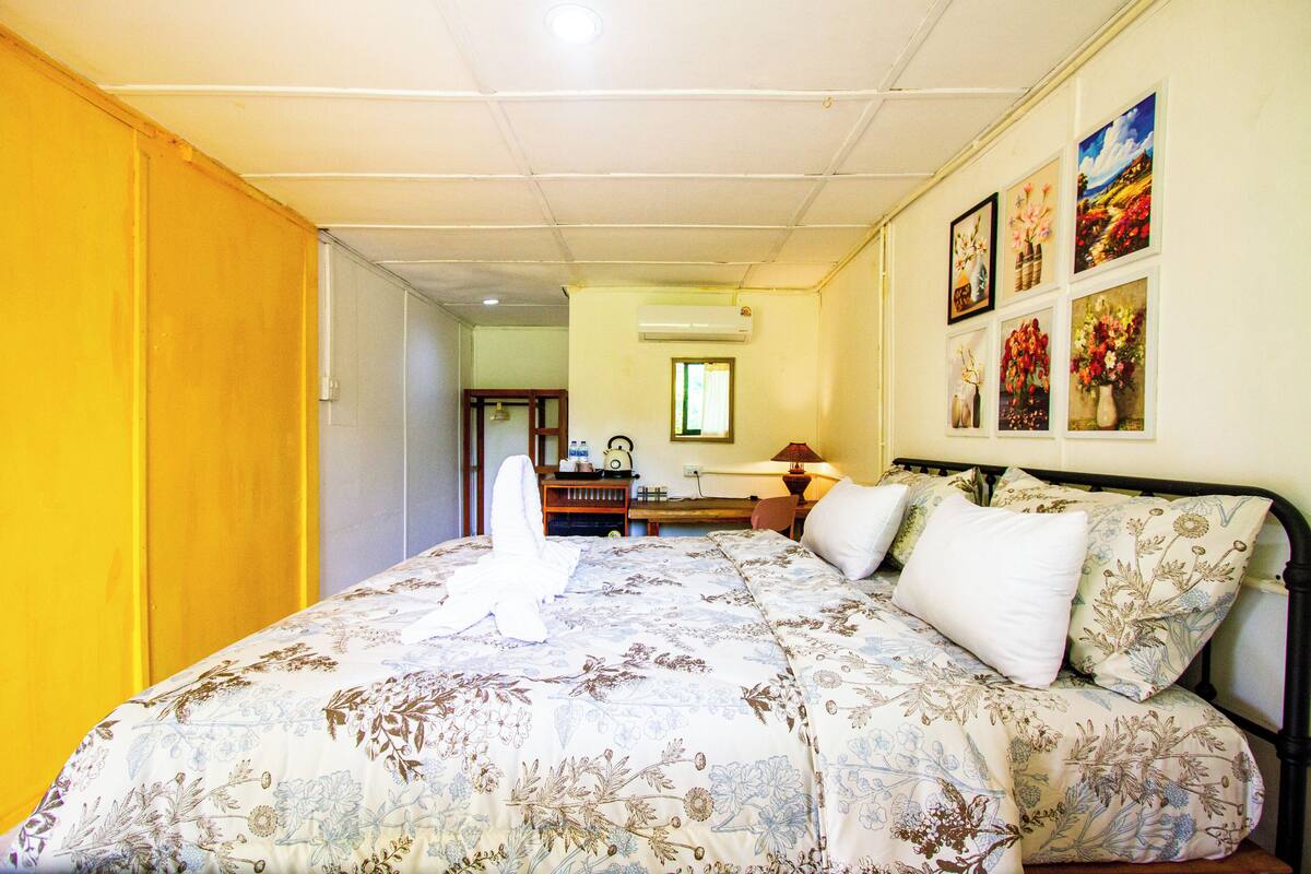Un dormitorio con cama, escritorio, silla y ventana.