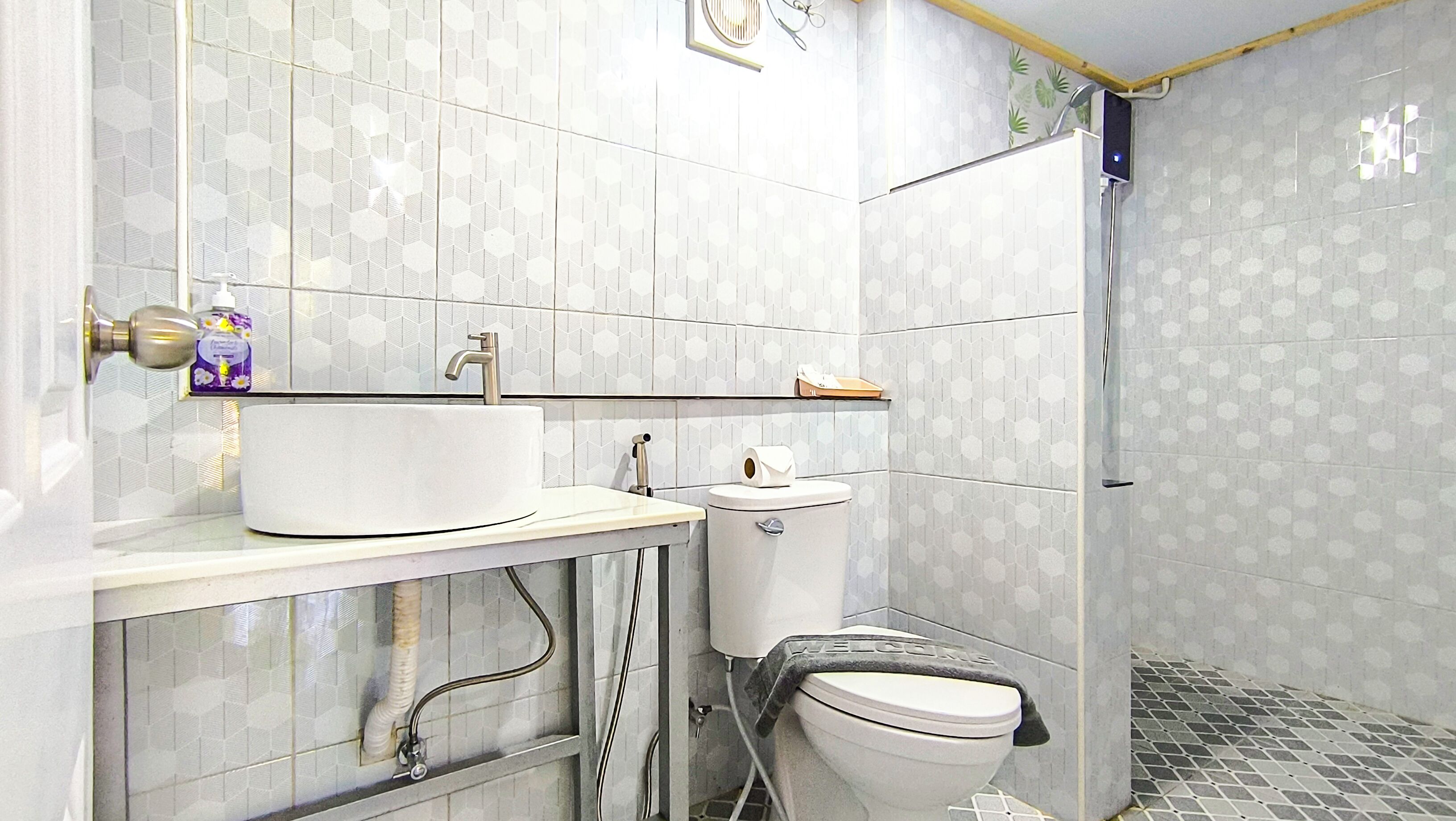 A bathroom with a white sink, toilet, and shower.