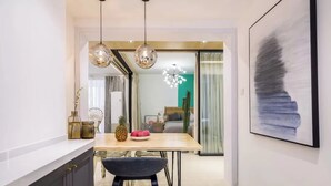 A modern kitchen with a wooden table, two pendant lights, and a chair. - Book and Bed - Lujiazui (Shanghai)