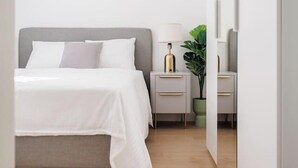 A bedroom with a bed, bedside tables, a lamp, and a hanging light fixture. - Stylish City Suite • Balcony • Augarten & Center (Vienna)
