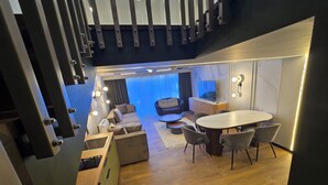 A modern interior with a dining area, sofa, and a TV. - Apartments Lura (Peć)
