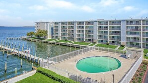A waterfront hotel with a pool, a dock, and a view of the water. - Thunder Island 161d 2 Bedroom Condo (Ocean City)