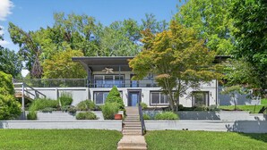 A modern two-story house with a front porch, a staircase leading to the entrance, and a well-maintained lawn. - Lakefront Getaway With Private Dock & Scenic Views 3 Bedroom Home (Kingsport)