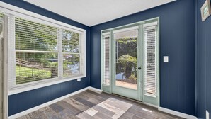 A room with dark blue walls, a wooden floor, and large windows with white blinds. - Lakefront Getaway With Private Dock & Scenic Views 3 Bedroom Home (Kingsport)