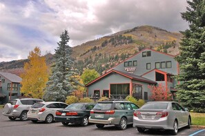 A lodge with a mountain backdrop, multiple parked cars, and a clear sky. - Telluride Lodge 324 1 Bedroom Studio (Telluride)