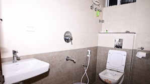Une salle de bain avec un lavabo, des toilettes et une douche.